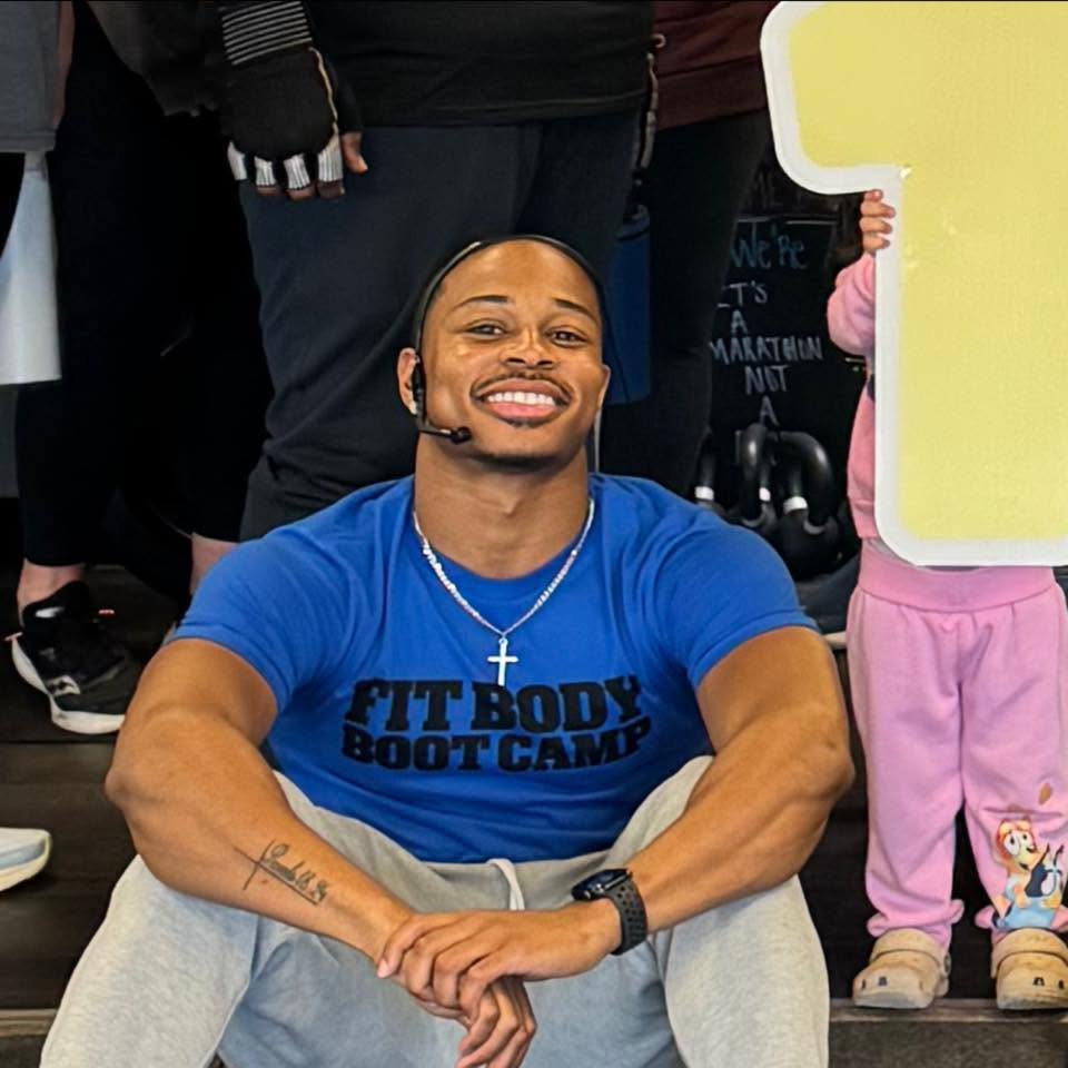 Coach smiling in a Fit Body Boot Camp shirt after class